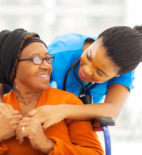 elderly woman and caregiver smiling at each other